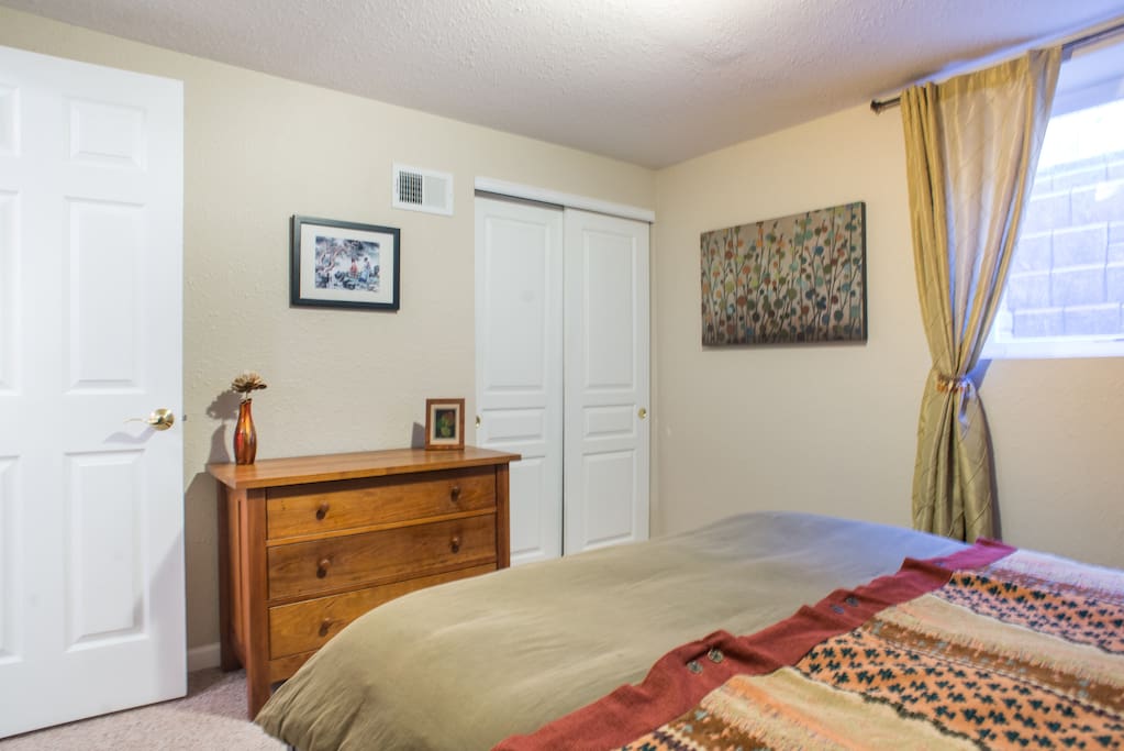 Private bedroom with closet, hangers, dresser, and more