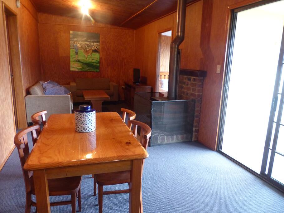 Dining and living rooms with fireplace and opening on to verandah with great views