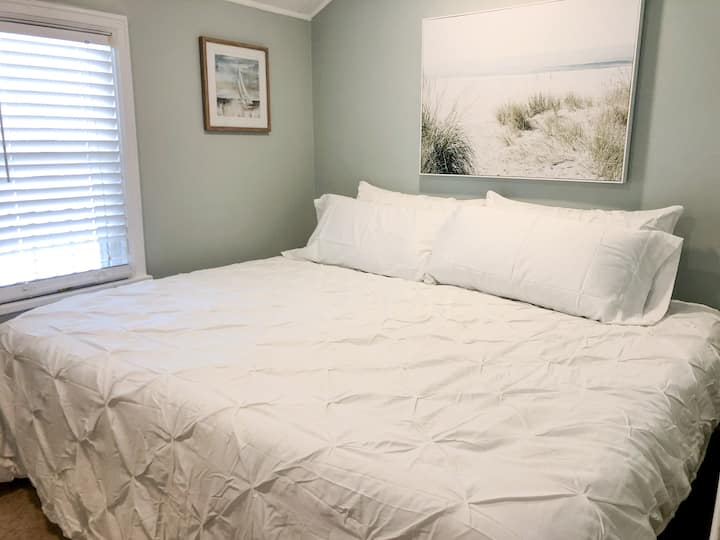 Master bedroom has a king bed with down comforter and extremely comfortable bedding and pillows - bright, white, and freshly clean for your stay. 