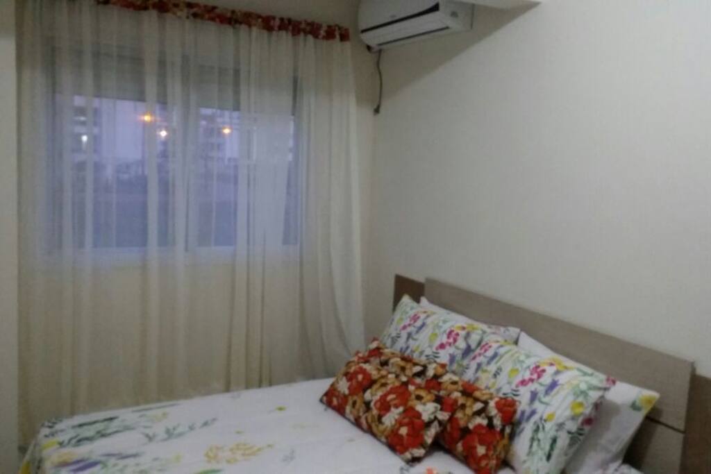 quarto social de casal com ar condicionado.