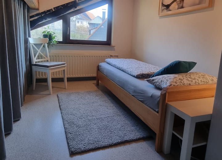 Chambre simple pour la 5ème personne.
La machine à laver et les ustensiles de travail sont cachés derrière le rideau.