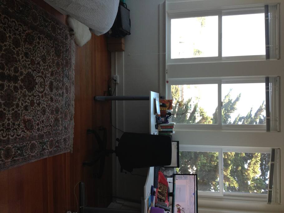The room is 1/2 windows with a spectacular view, wood floors, and a large desk are shown here.