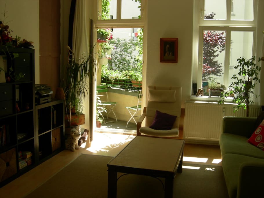 Living room with a very green, sunny balcony
