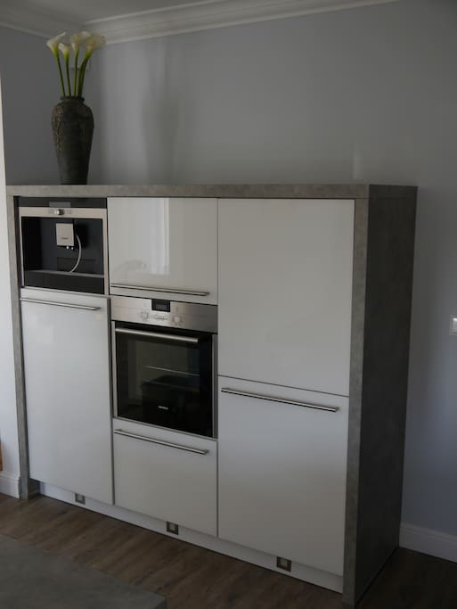 "Elektro-Ecke" in der Küche mit Kühl-/Gefrierschrank und Backofen