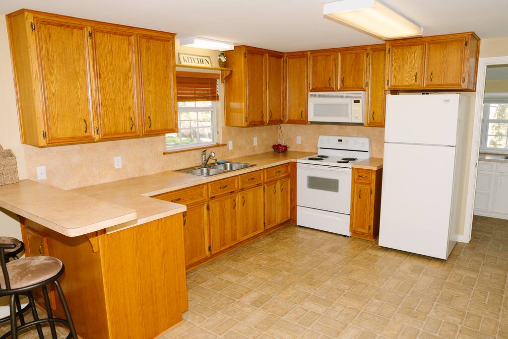 Full kitchen with all the necessities and a breakfast bar with stools.