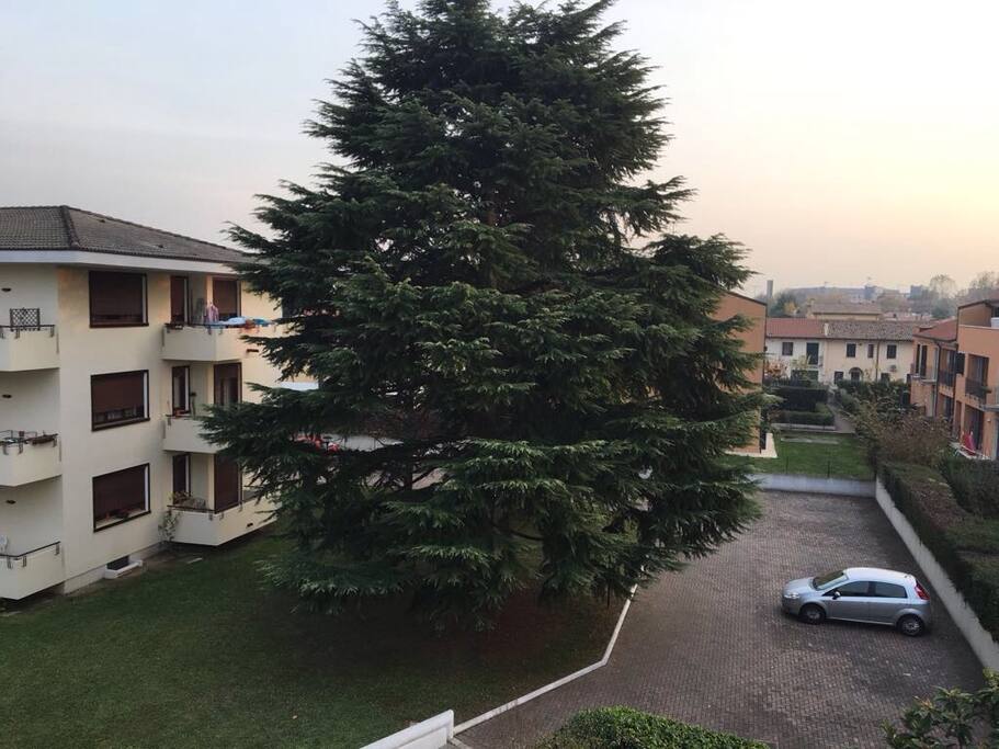 Vista dal balcone della camera da letto sul cortile interno recintato, con posto auto e rampa di accesso al garage privato.