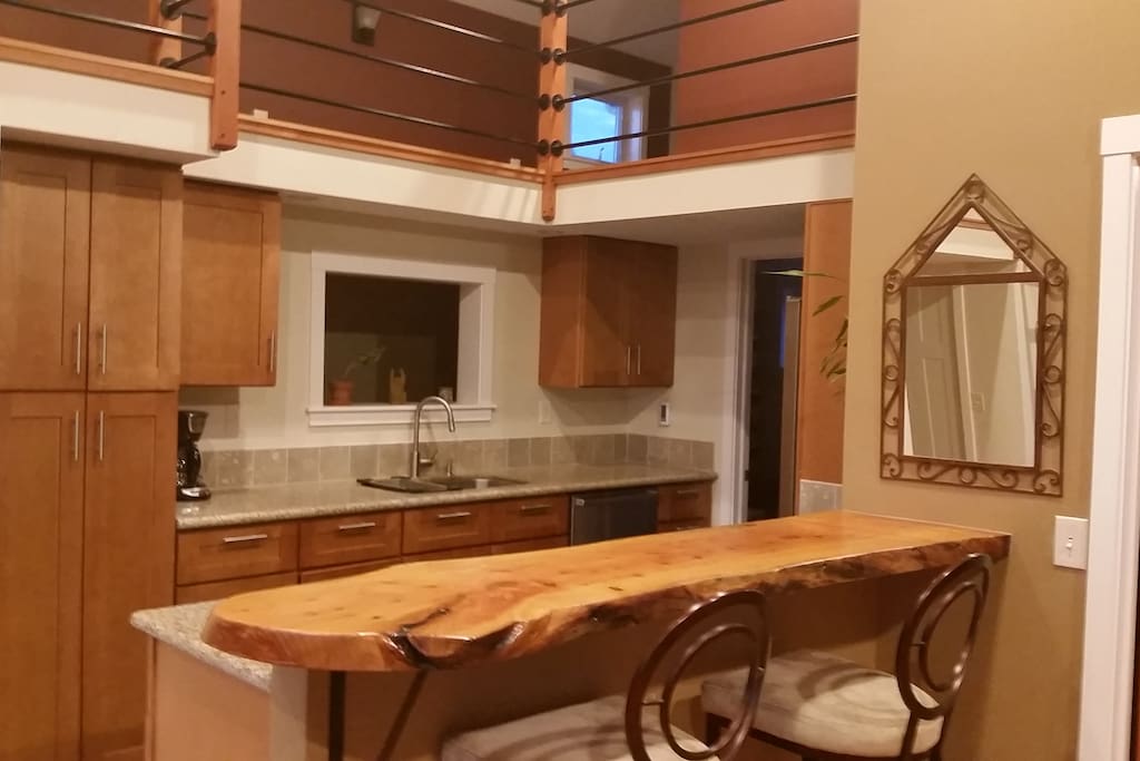 Beautiful kitchen with stainless appliances, heated slate floors and a hand made eating bar