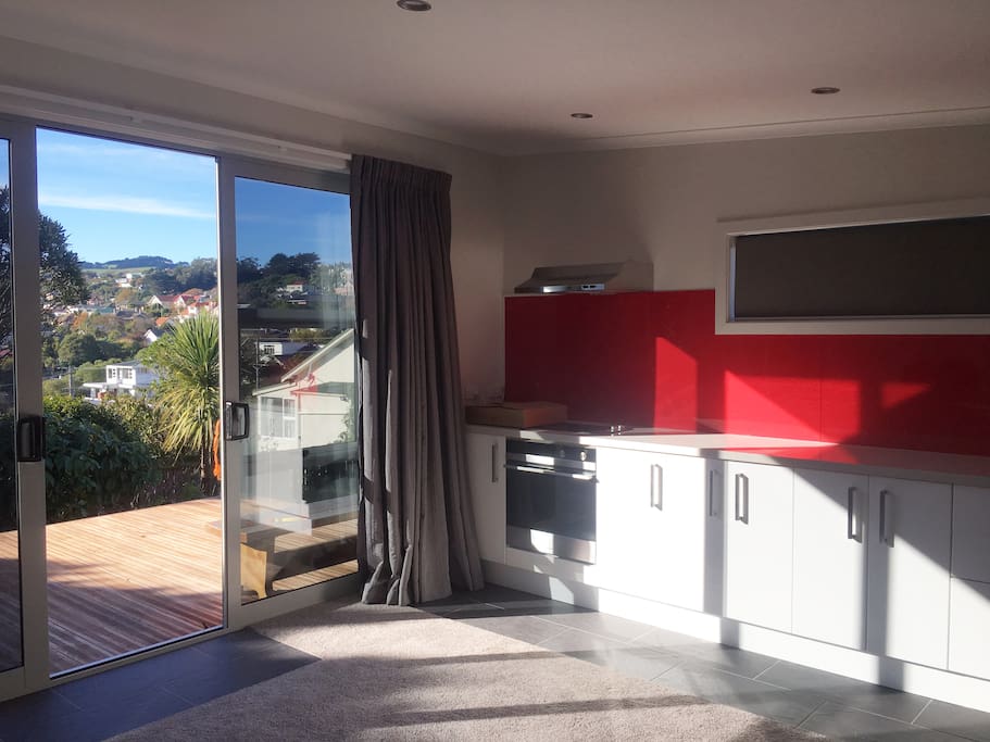 View from Lodge living area to Deck, Garden, and Otago Peninsula Hills
