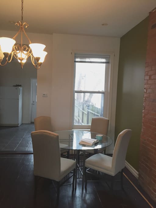 Dining area with tall ceilings and exposed brick.