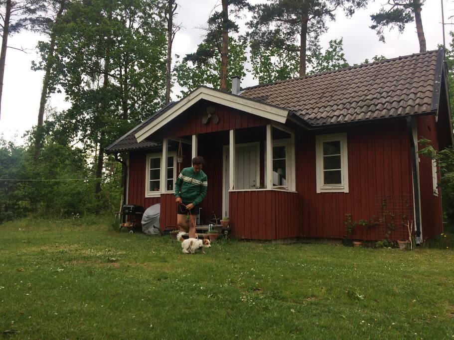 In front of the house is a small garden with a grill and some furniture.