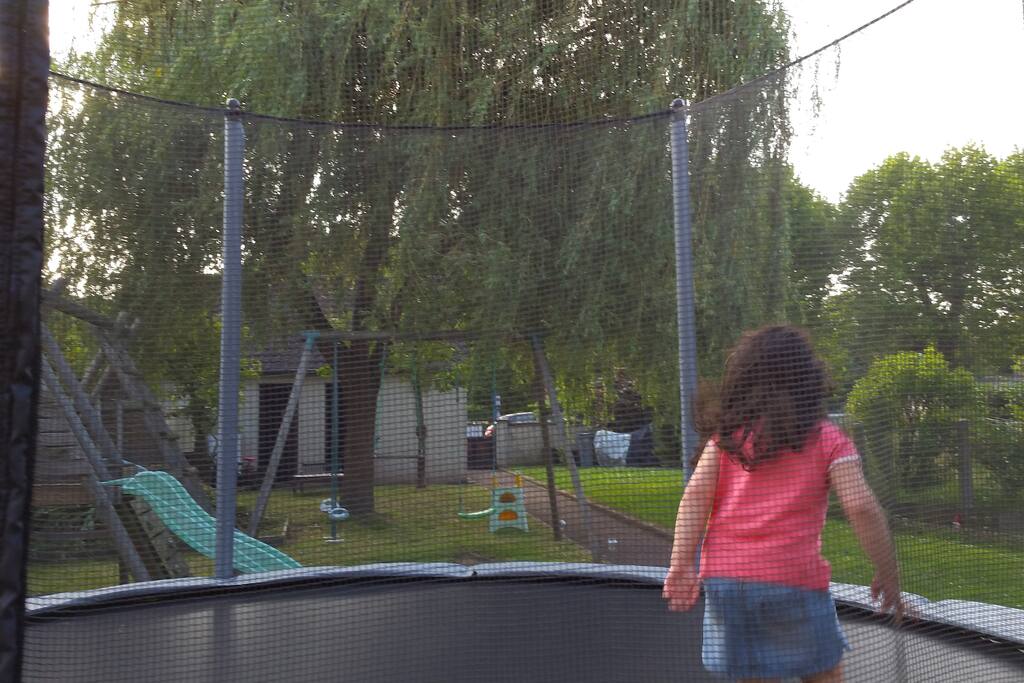 Jardin avec barbecue, tables de jardin, ballançoire, trampoline et toboggans
