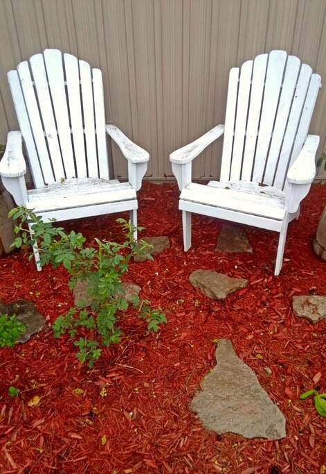 Detail of the front grden overlooking the street, including a small rose garden and wooden muskoka chairs. A peaceful place to observe and get to meet the neighbours!