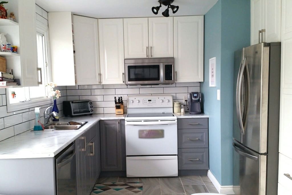 Newly renovated kitchen with double stainless steel fridge, dishwasher, toaster oven, microwave, and stove/oven. Laundry also available on site.