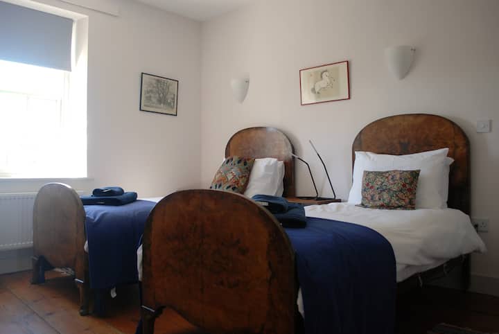 Spálňa dva so starožitnými rámami orechových postelí.