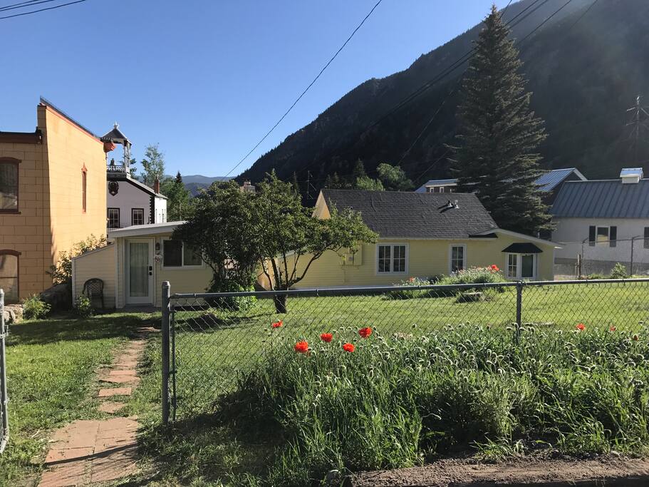 Fenced Backyard from parking area. Museum to the left and to the right. Cottage entrance straight ahead. Common area for the two properties.