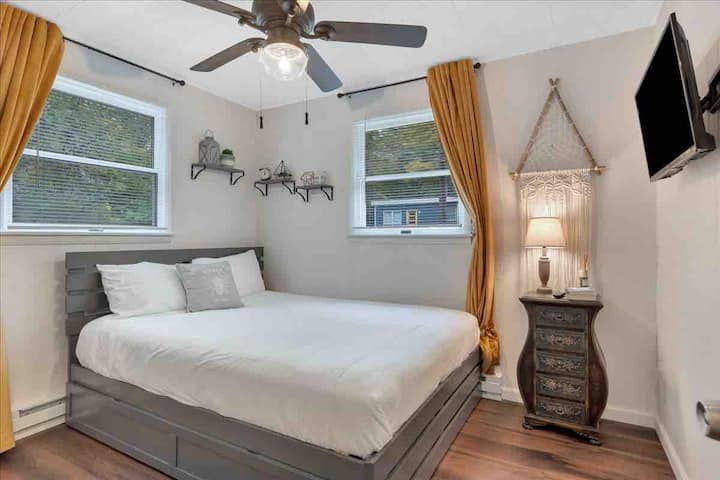 Queen bed with sheets, pillows and duvet. Has pull out trundle underneath. Smart TV. One end table at foot of bed. Fan, closet.