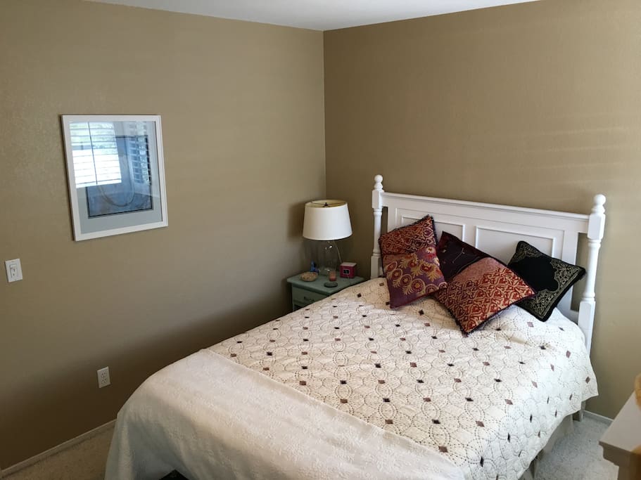 The room offers wifi, a side reading lamp, and a comfortable queen size bed.