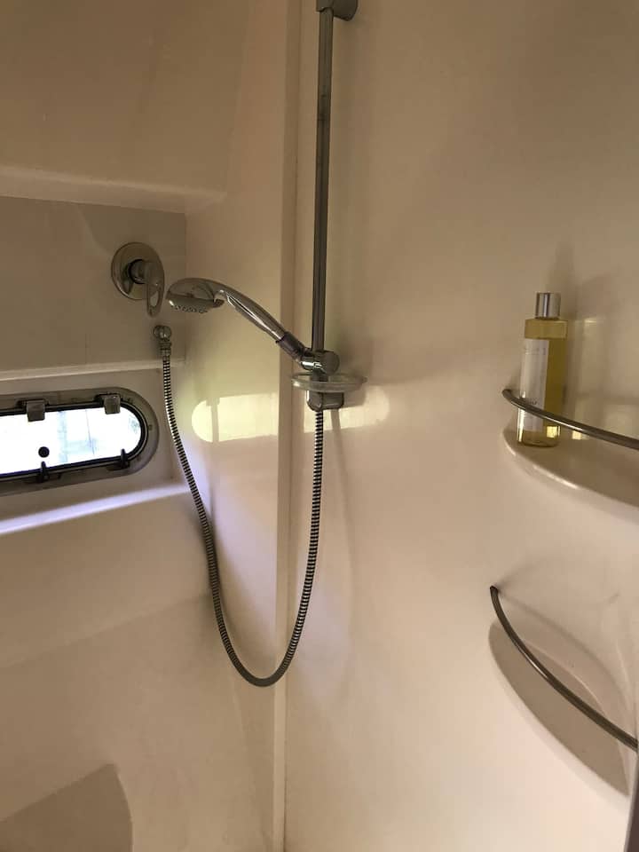 Душ кабина пред предната дървена колиба . 