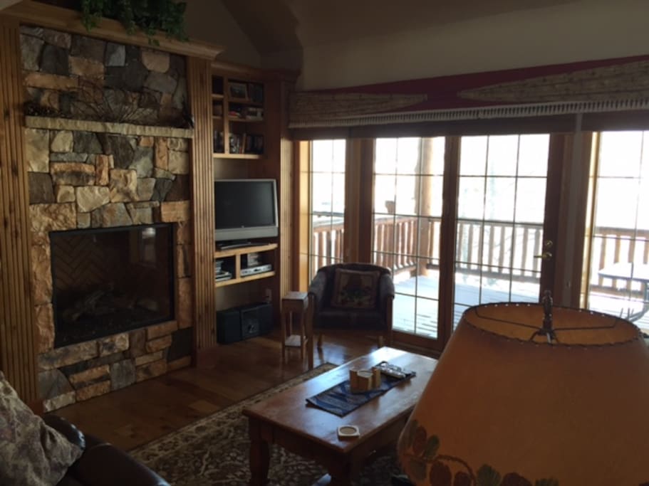 Front Room with rock fireplace opening onto lg deck
