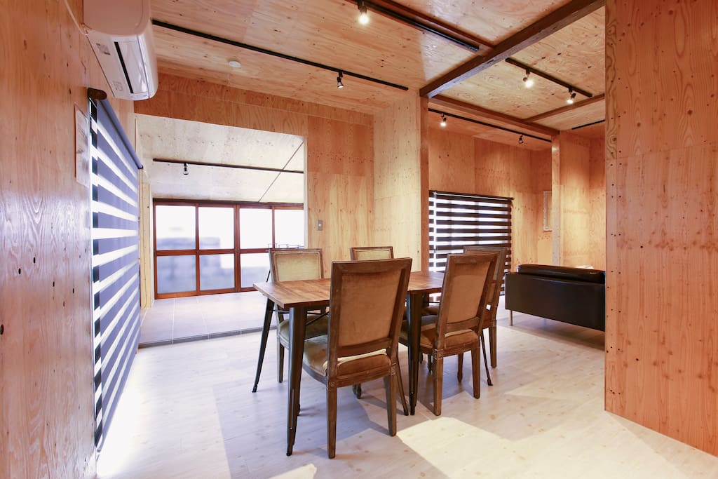 Dining table, inside kitchen space is a counter with 4 chairs
