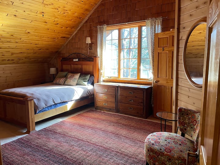 Queen bedroom from the door.  This bedroom is big & has two small dressers, a futon & a closet.  A full bathroom attached, with a bathtub for soaking or bathing the kids.