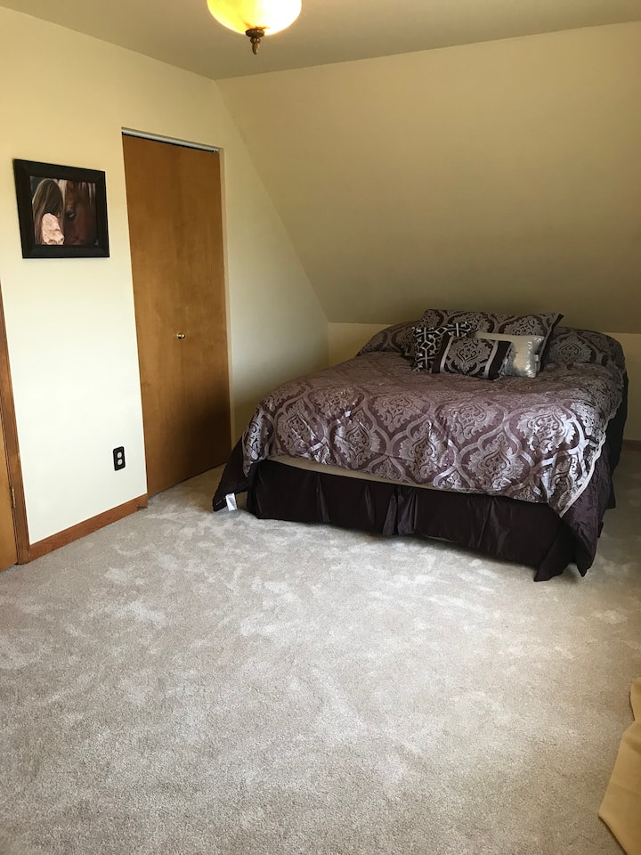 غرفة نوم في الطابق العلوي بسرير ملكي إمبريال وسرير كامل الحجم. تم تجديدها للتو.