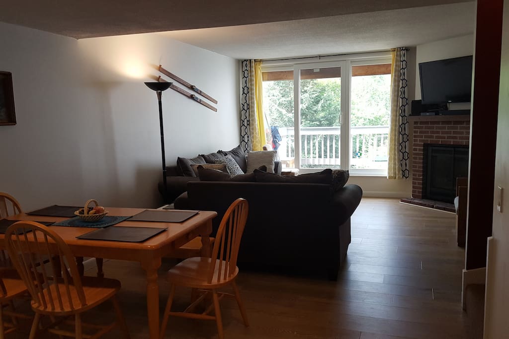 Open living and dining area with access to the balcony and mountain views.