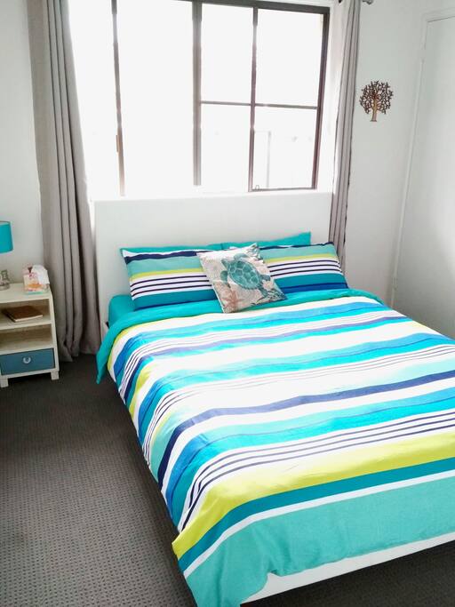 Your bedroom features a queen sized bed with a comfy duvet and medium pillows. There is a ceiling fan, a heater and floor fan in the closet.