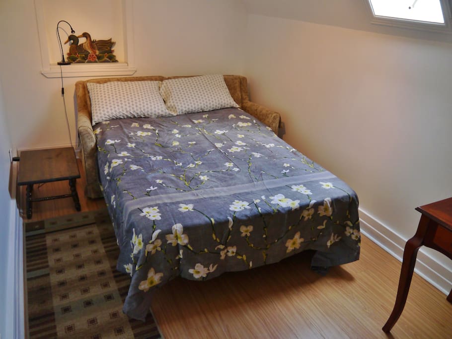 The 'Spare Room' in bed mode. It has a pull-out sofa double bed with extra padding, and a desk. Guest groups of two or more may use it. For example, two guests may sleep in separate beds.
