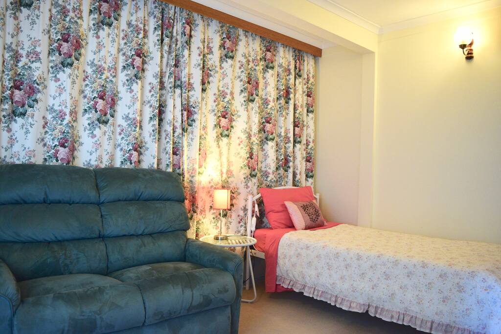 This large bedroom contains a queen-size bed. The other end of the room contains another space which can be used as a dressing room, a lounge or second bedroom.