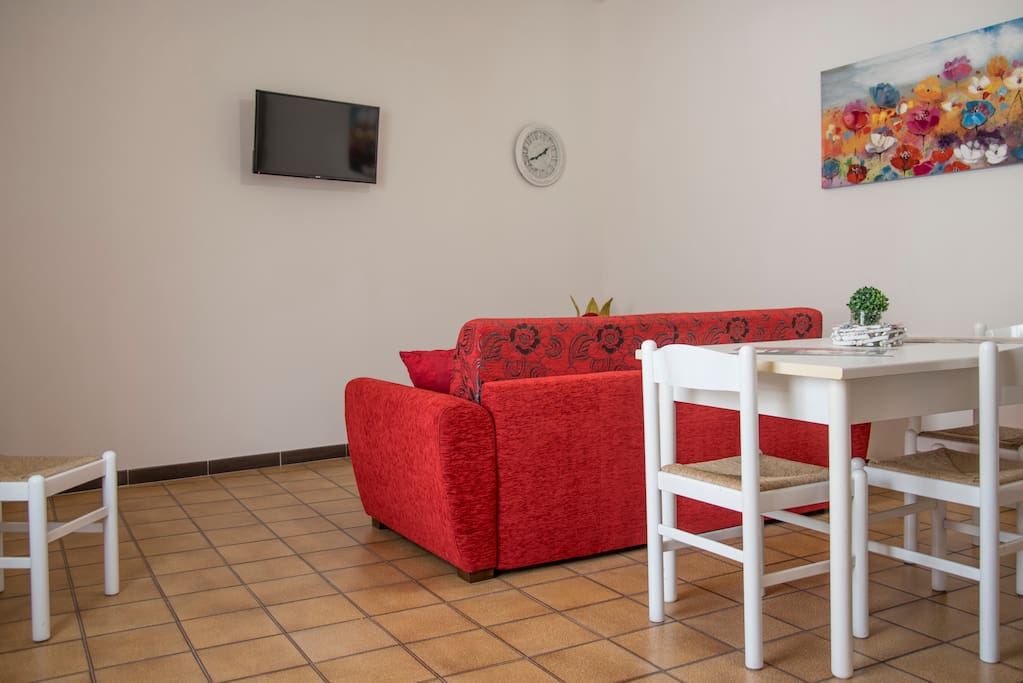 Zona living con divano letto matrimoniale e TV schermo piatto/ condizionatore