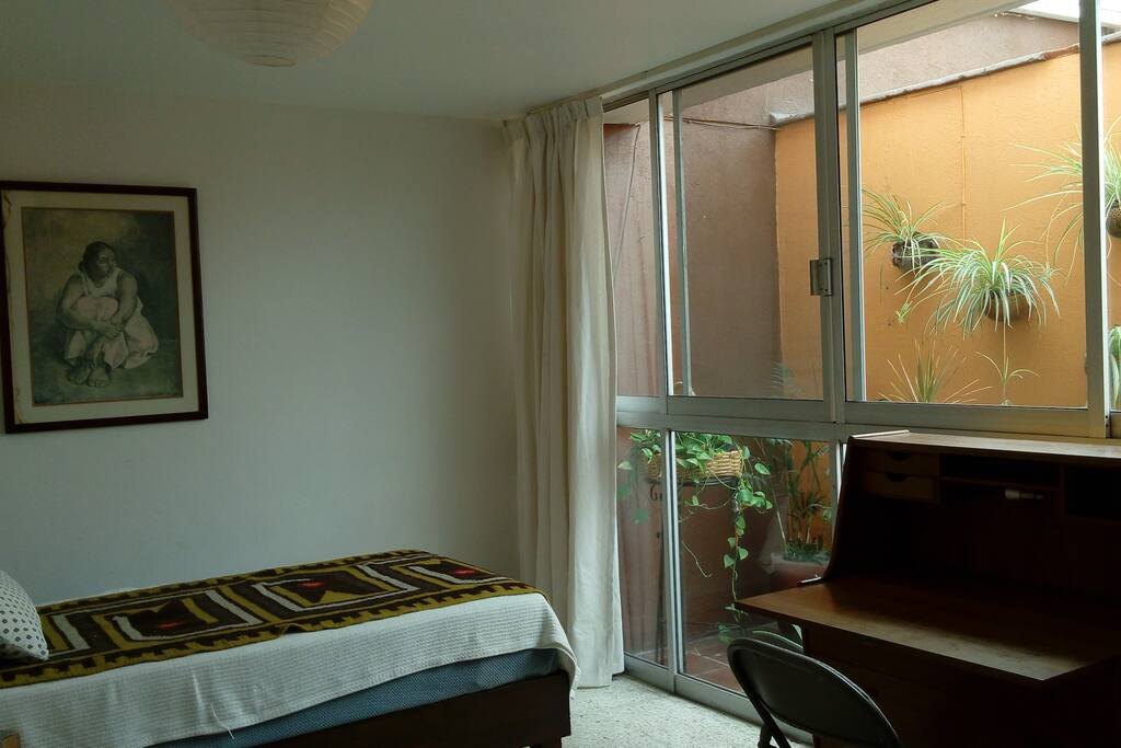 View of the bedroom from the door: bed, desk and window