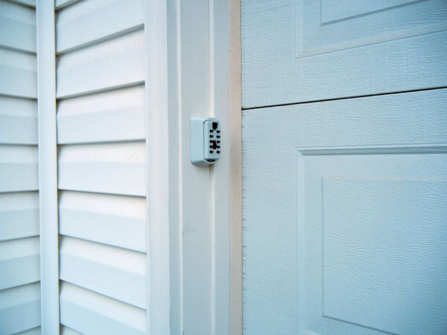 Lockbox with key on front door frame of garage