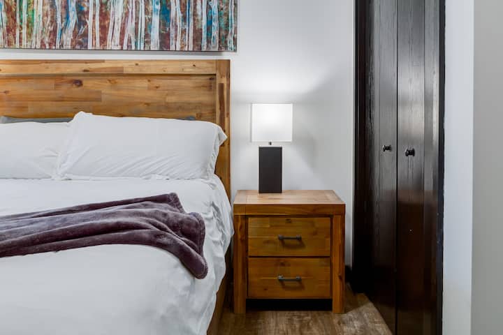 Hoofdslaapkamer met comfortabel queensize bed en uitzicht op de bergen