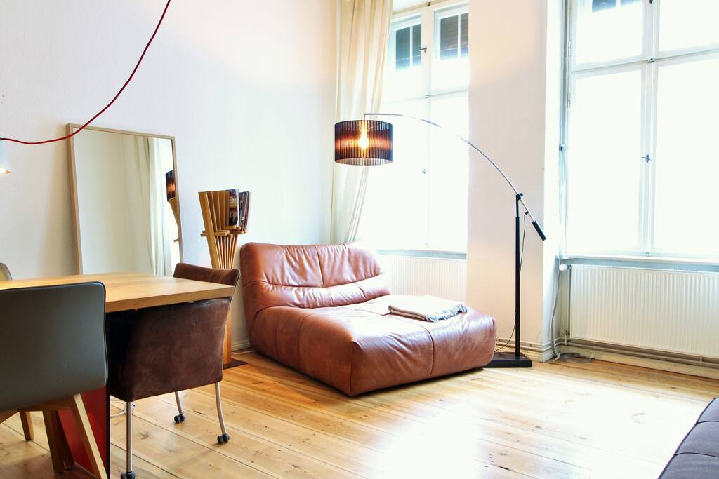 Cozy couch right next to the big windows that bright up the whole room.