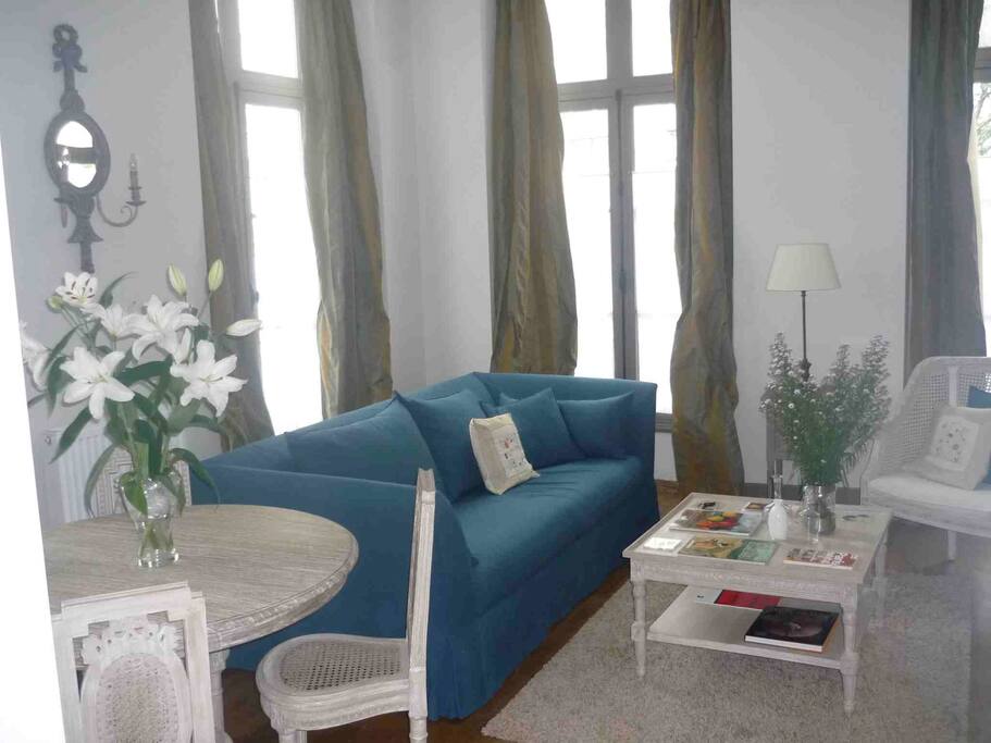 Corner living room, double exposure, high ceilings and windows, solid wood flooring.