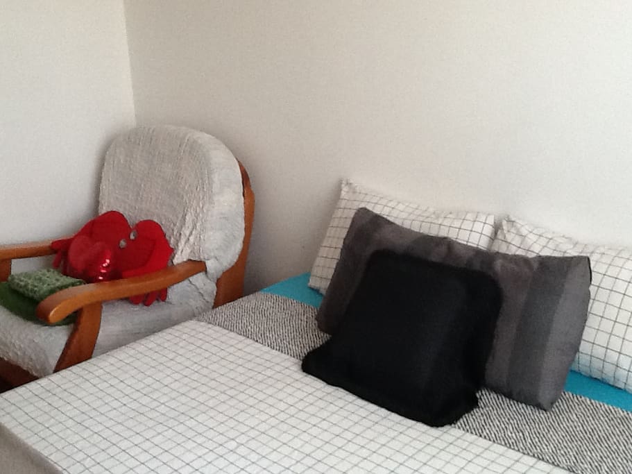 Cama de 135cm, butaca de descanso y juego de toallas de baño.