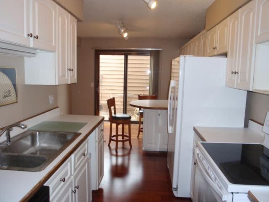 Kitchen and dining room with breakfast bar, wine rack, tons of cupboards filled with household items