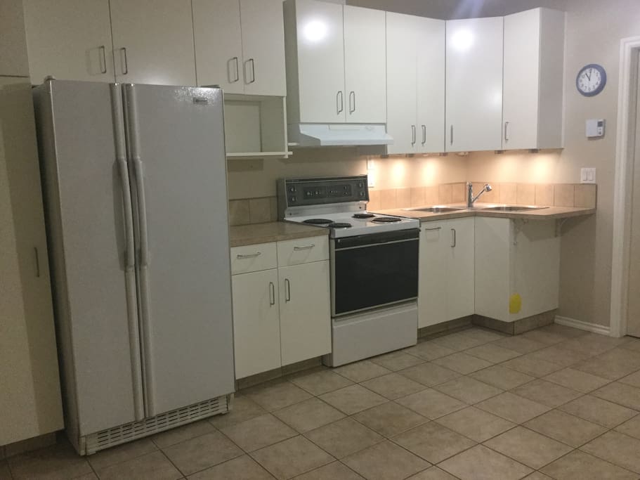 Kitchen with full size fridge and stove and lots of cupboards.