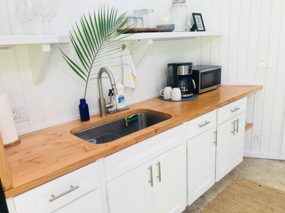 Kitchenette with fridge, microwave, coffee maker, toaster and single induction hot plate for cooking.