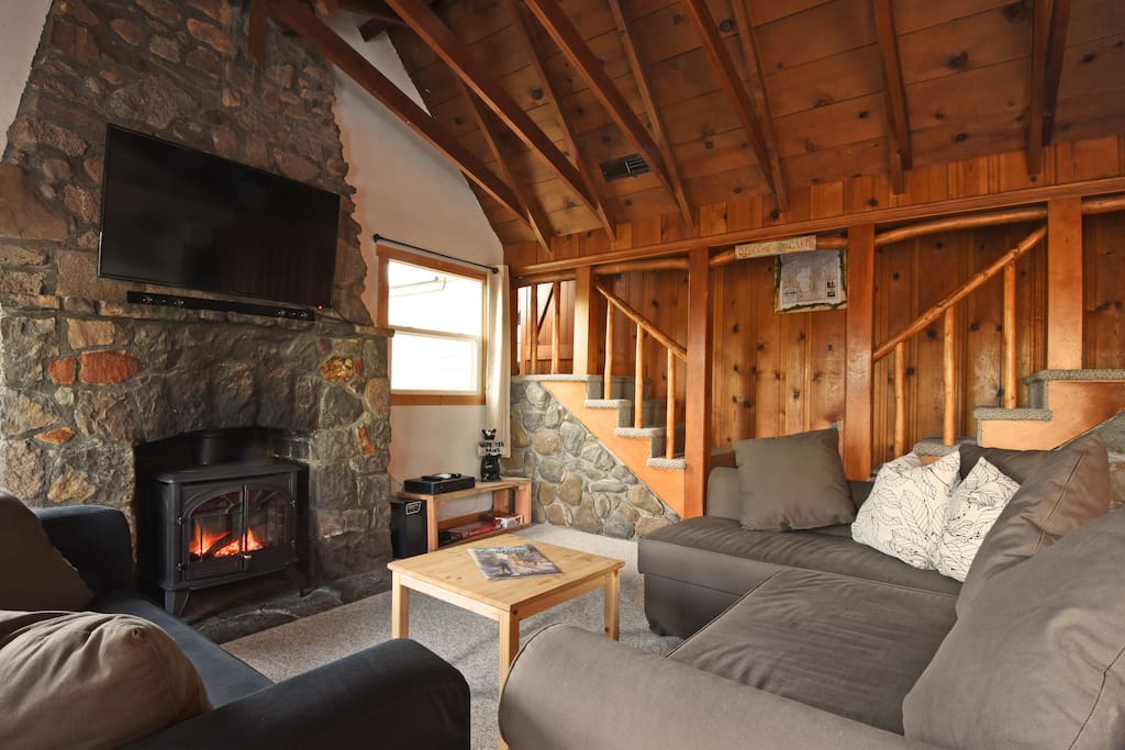 The living room, featuring the TV and a wood burning stove