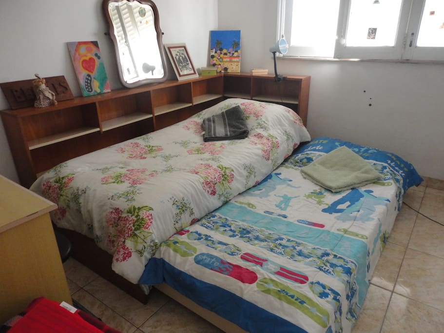 Duas camas, estante com compartimentos (gavetas) à volta.