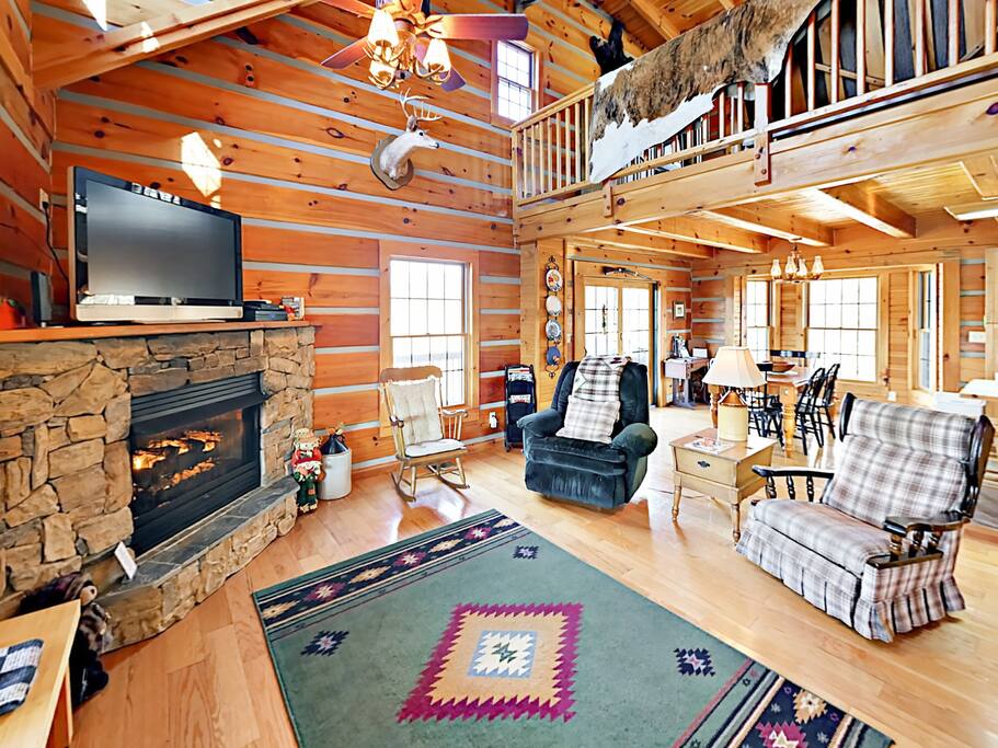 Seating for 5 in the living area with a flat screen TV, complimentary Wi-Fi, and a cozy gas fireplace.