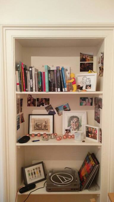 Our book shelf; showing some homemade art, interesting reads and personal photographs