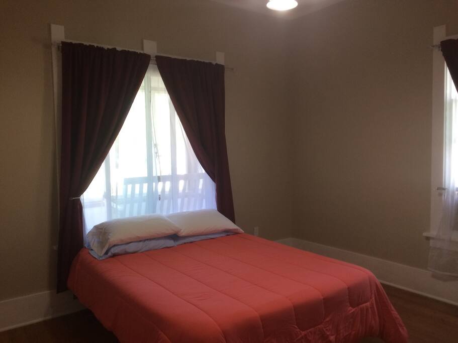 Guest bedroom with window to front porch and window to side of house