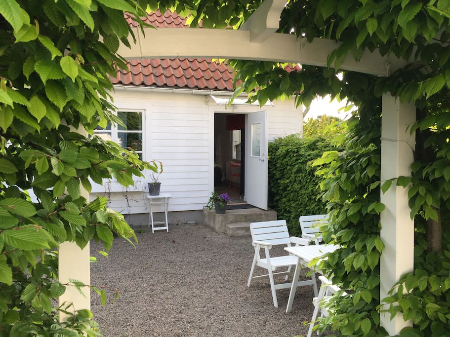Härlig uteplats i grön täppa med filtar o kuddar för användning utomhus