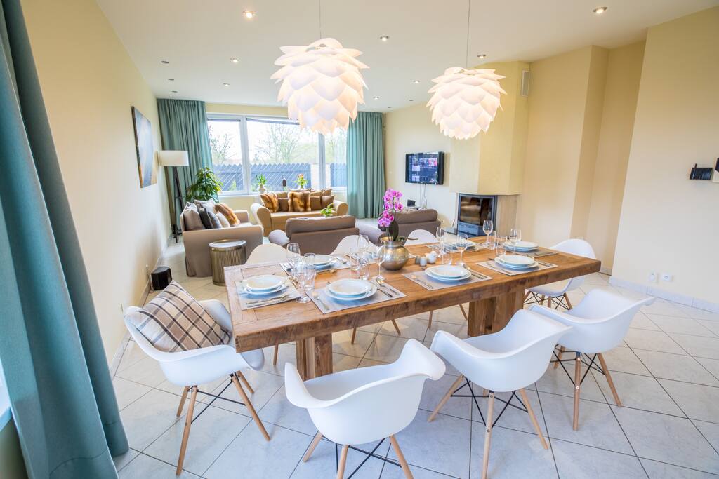A spacious living room with a beautiful wooden table and a TV with Netflix, YouTube