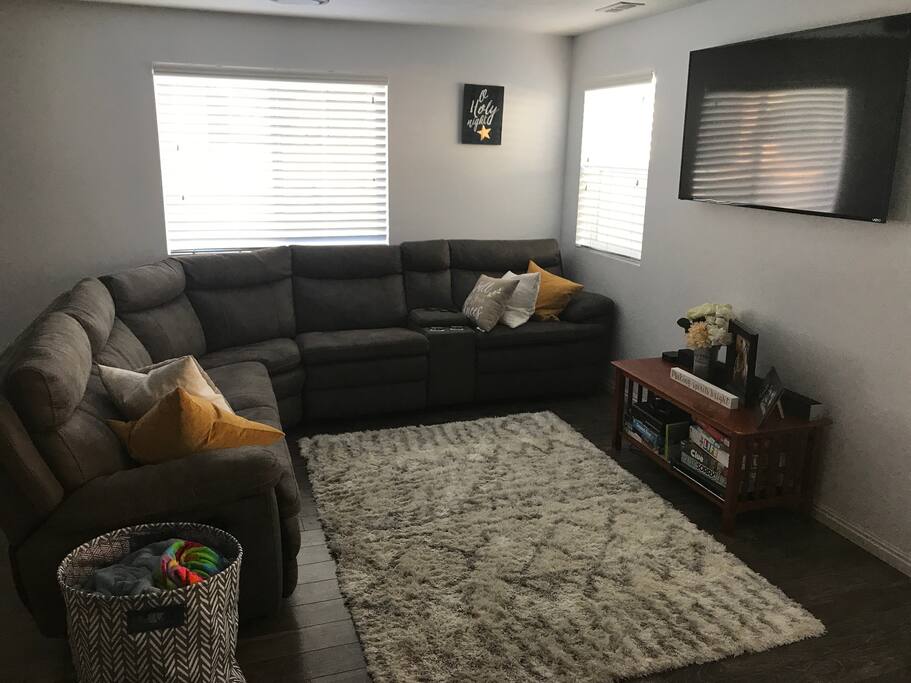 Living room with 60 inch tv, Apple TV, DVD player, and super comfy couch with lay down recliners!