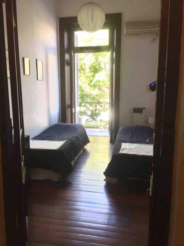 ห้องนอนแรกพร้อมเตียงคู่ 2 หลังเครื่องปรับอากาศและเครื่องทำความร้อนโดยการถ่ายภาพที่สมดุลแสงธรรมชาติและทางออกระเบียง 