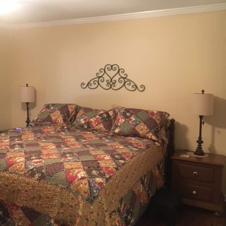 Pumzika katika chumba cha kulala cha Master kwenye kitanda cha kifahari, kirefu cha mfalme kilicho na meza za kulala, taa na kituo cha kuchaji pande zote mbili.    Sehemu za kufungia mizigo zinaweza kupatikana kwenye kabati lenye nafasi kubwa.